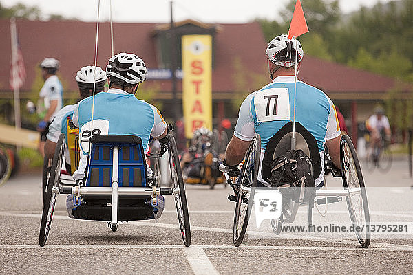 Men with spinal cord injury and leg amputee participating in a handcycle race