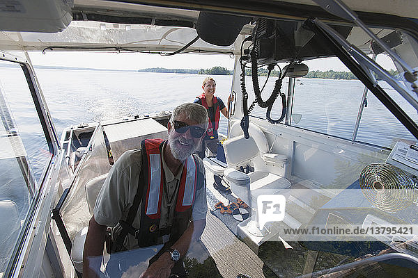 Two engineers on service boat preparing to take water samples from public water supply