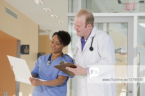 Male doctor discussing a medical report with a female nurse