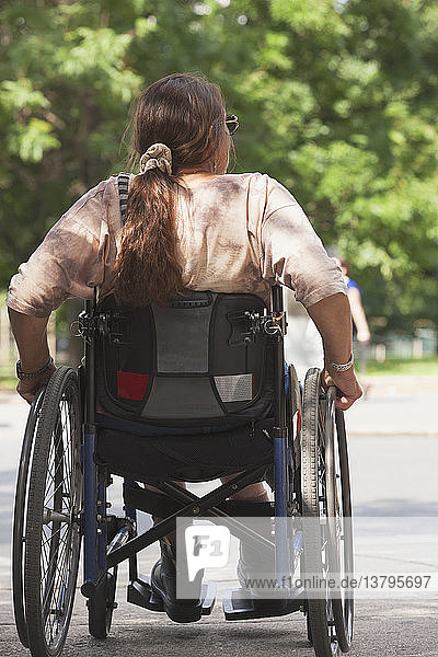 Frau mit Querschnittslähmung überquert die Straße an einem barrierefreien Zugang  Boston  Massachusetts  USA