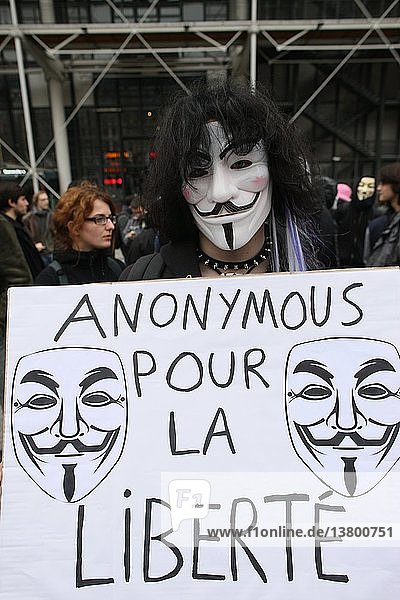 Demonstrant mit einer Guy-Fawkes-Maske  dem Markenzeichen der Anonymous-Bewegung und einer Figur aus dem Film V wie Vendetta  Frankreich