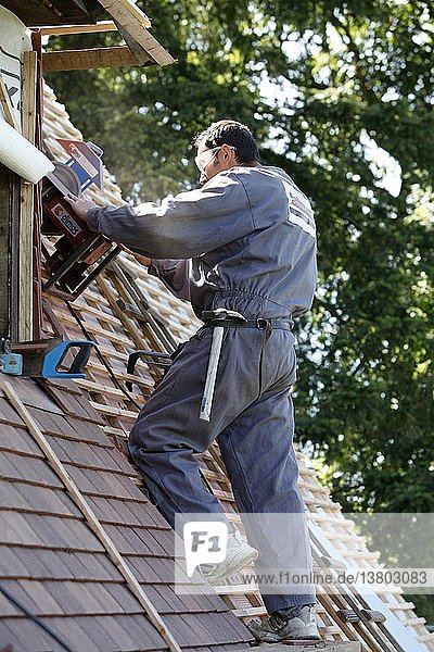 Arbeiter  der ein neues Dach repariert.