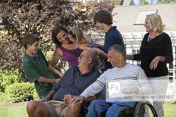 Porträt einer Großfamilie mit einem Mann mit Rückenmarksverletzungen im Rollstuhl