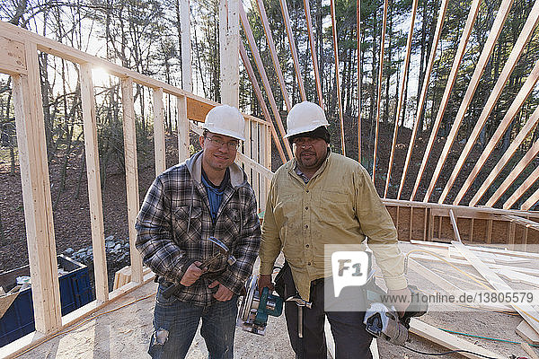 Portrait of carpenters with framing tools