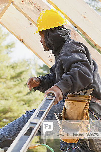 Carpenter using a level in house construction