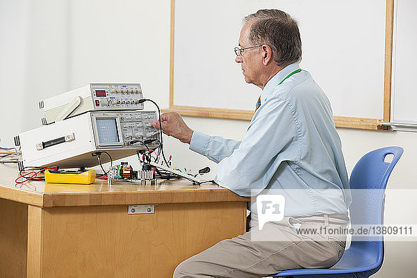 Professor stellt Oszilloskop-Auslösepegel im Elektronikunterricht ein