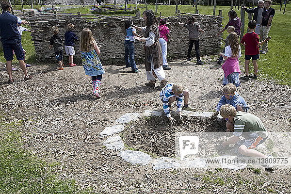 Kinderaktivitäten in einem eisenzeitlichen keltischen Haus aus Flechtwerk und Lehm Castell Henllys  Pembrokeshire  Wales