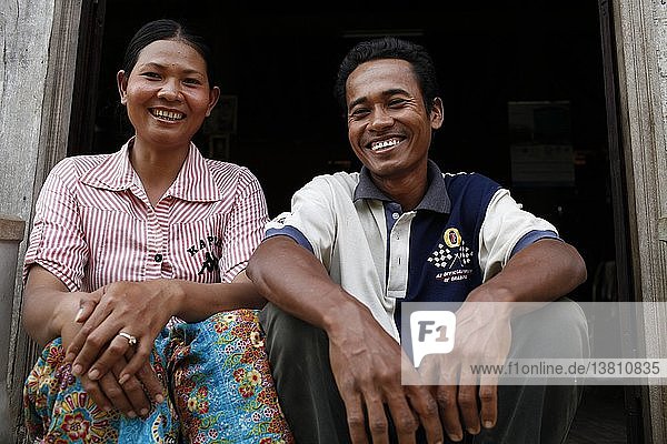 Am Tron  a client of HKL microfinance  outside her home with her husband  Tamang  Cambodia.