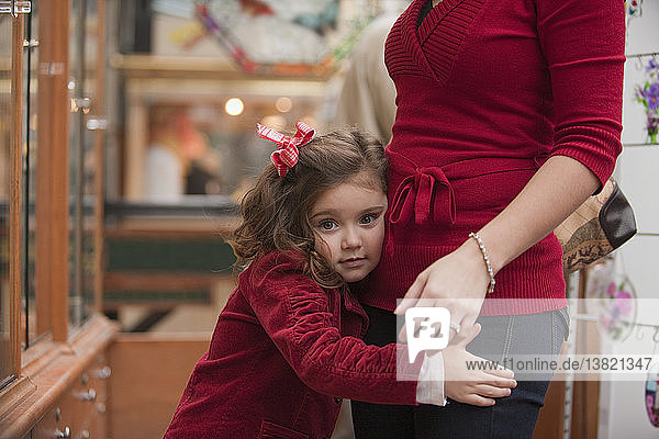 Portrait of a girl hugging her mother in a store