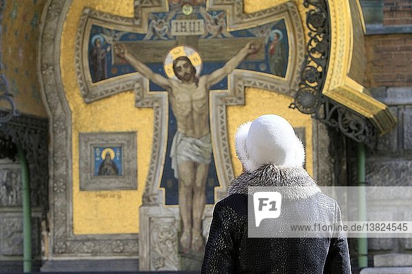 Russische Frau betend vor Christus  der Kirche des Erlösers auf vergossenem Blut oder der Kirche der Auferstehung.