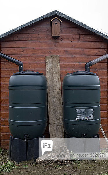 Zwei Wassertonnen zur Veranschaulichung des Konzepts der Wassereinzugsgebiete  die sich auf dem Dach befinden