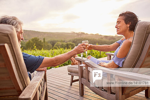Pärchen entspannt sich mit Champagner auf der Terrasse des Resorts