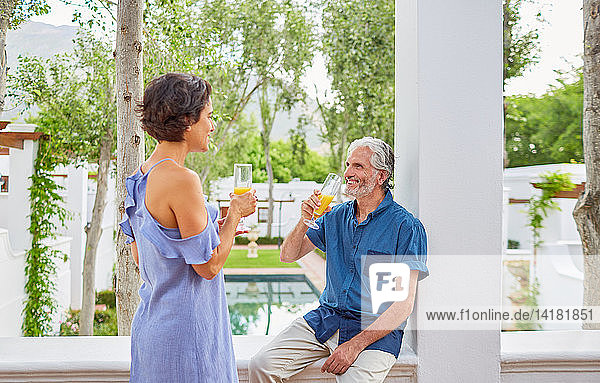 Älteres Paar trinkt Mimosen auf dem Hotelbalkon