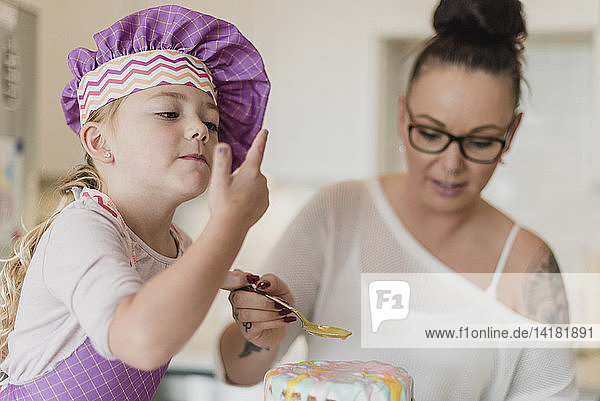 Mother and daughter decorating cake