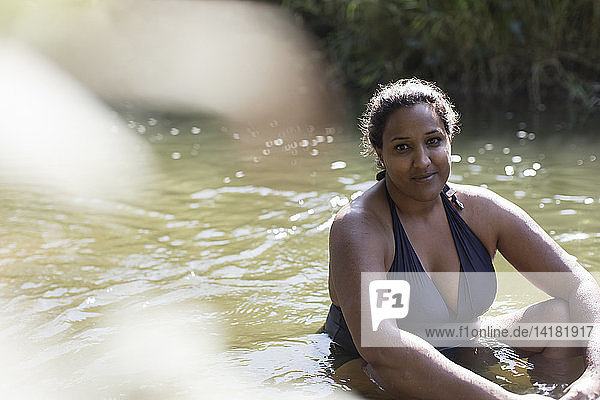 Portrait smiling woman relaxing in sunny river