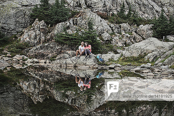 Portrait couple hiking  resting at rocky lake  Dog Mountain  BC  Canada