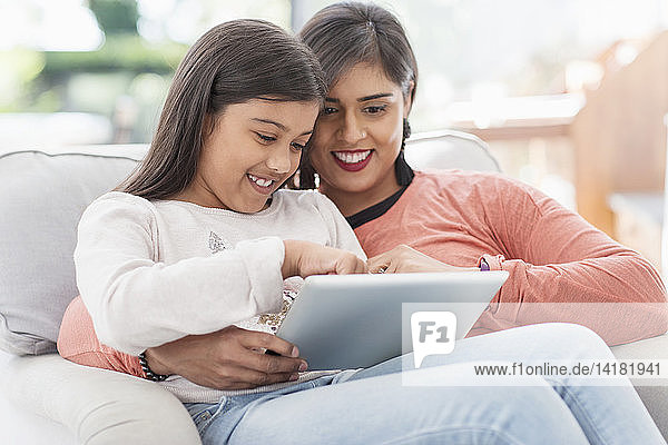 Glückliche Mutter und Tochter mit digitalem Tablet