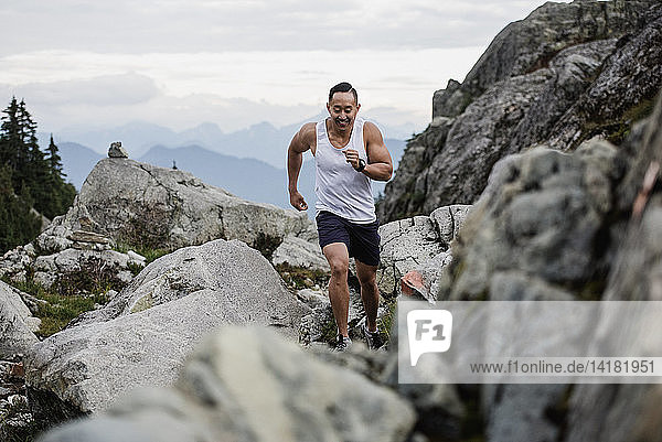 Male hiker running over rocks  Dog Mountain  BC  Canada