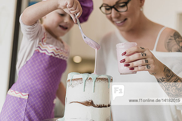 Mutter und Tochter dekorieren Kuchen