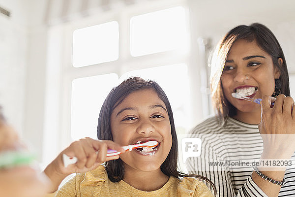 Portrait glückliche Mutter und Tochter beim Zähneputzen im Badezimmer