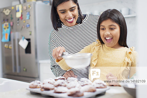 Mutter und Tochter backen Muffins in der Küche
