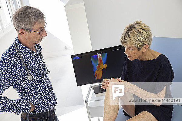 Eine Frau konsultiert einen Arzt wegen Schmerzen in ihrem Knie.