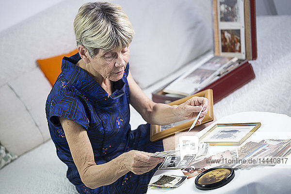 Alte Frau schaut sich Fotos an