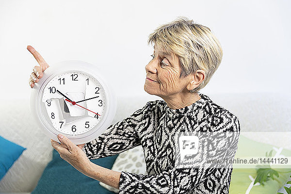 Elderly woman with a clock worn by time.