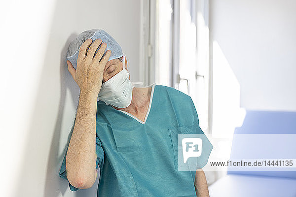 Ein Chirurg  der von seiner Arbeit erschöpft ist.