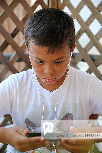 Ein 11-jähriger Junge benutzt ein Mobiltelefon in Salento  Italien.