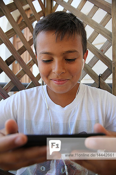 Ein 11-jähriger Junge benutzt ein Mobiltelefon in Salento  Italien.