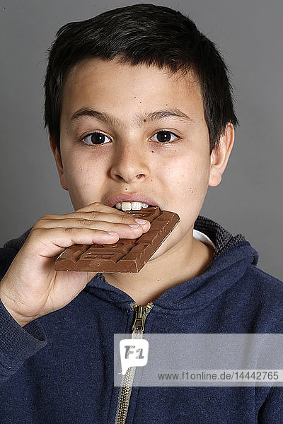 12-jähriger Junge isst Schokolade. Paris  Frankreich.