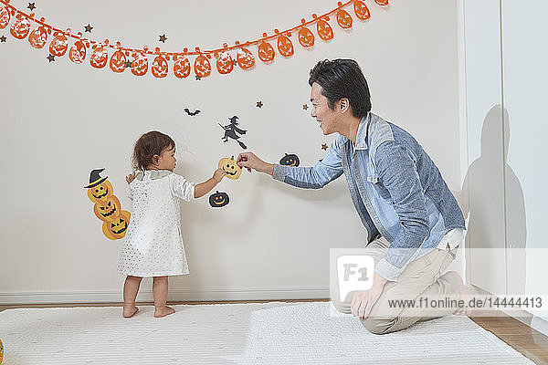 Japanisches Kind und Vater bereiten sich auf Halloween vor