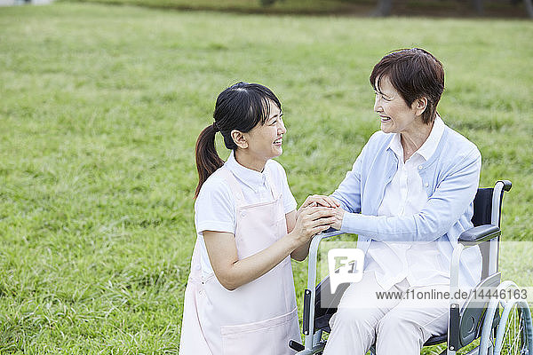 Japanese caretaker helping senior patient