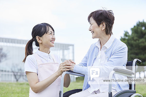 Japanese caretaker helping senior patient