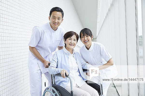 Japanische Pfleger helfen älteren Patienten