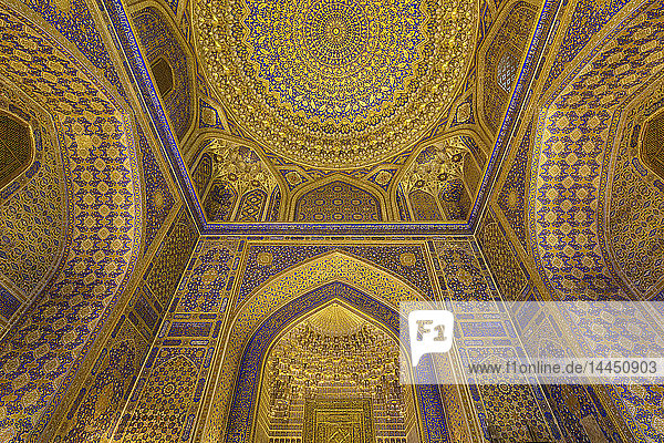 Das Innere  die blau und gelb verglasten Wände und die Kuppel eines Madrasa-Gebäudes in Samarkand.