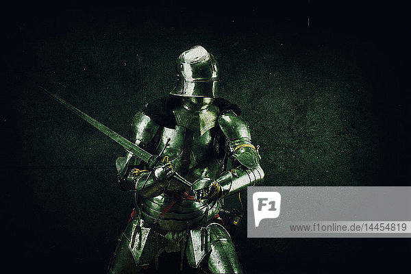 Porträt eines Ritters auf der Hut im Atelier auf schwarzem Hintergrund.