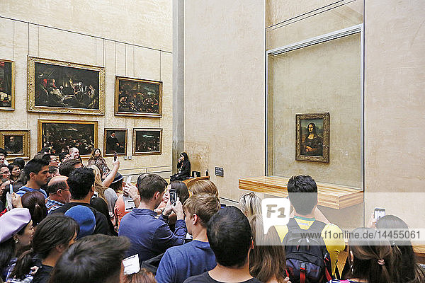 Paris 1st arrondissement  Louvre Museum. Department of Italian paintings.Tourists in front of the painting of the Mona Lisa admiring it and photographing it with smartphones.