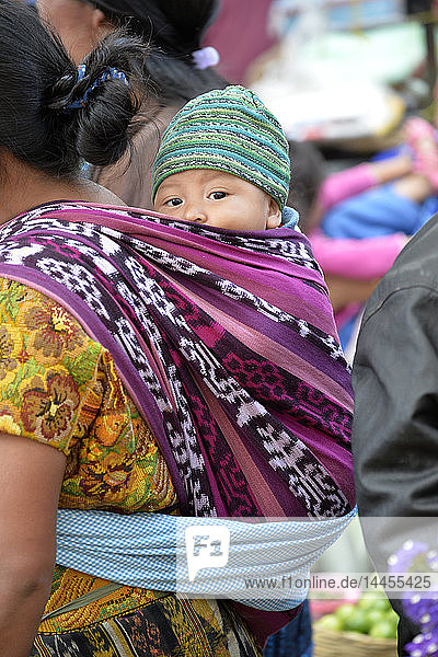 Guatemalan woman carrying child in sling on her back  lake of Atitlan  Solola market  Guatemala  Central America.
