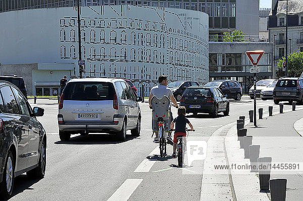 Frankreich  Region Pays de La Loire  Stadt Nantes  Fahrrad fahrende Personen auf einem Radweg neben dem Verkehr.