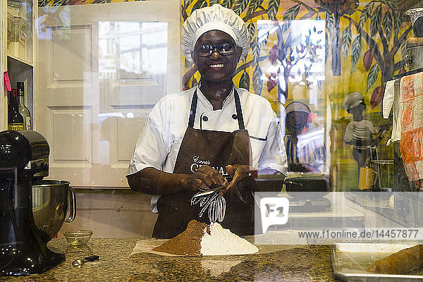 A women behind a window grinding cocoa ball  House of Chocolate  St-Georges  Grenada  West Indies  Caribbean Islands