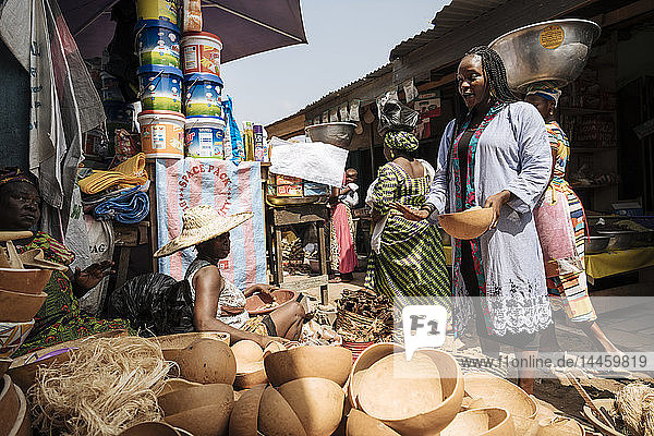 Frau wählt eine Holzschale an einem Marktstand in Accra  Ghana  aus