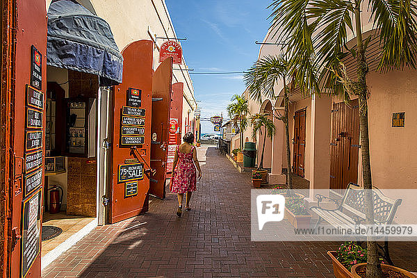 Frau geht an einem Geschäft in der Innenstadt von Charlotte Amalie  St. Thomas  US Virgin Islands  Karibik  vorbei