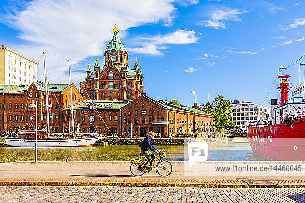 Uspenski Cathedral and cyclist by harbor in Helsinki Uusimaa Finland