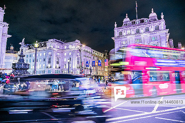 Ein Bus und ein Taxi fahren um den Piccadilly Circus  London  England  Vereinigtes Königreich