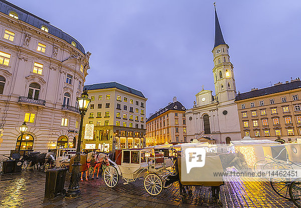 Christmas Market stalls and St. Michael Catholic Church in Michaelerplatz  Vienna  Austria