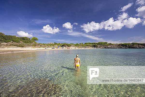 Ein Mädchen im Badeanzug spaziert im Wasser  Strand La Bobba  Insel San Pietro  Provinz Sud Sardegna  Sardinien  Italien  Mittelmeer