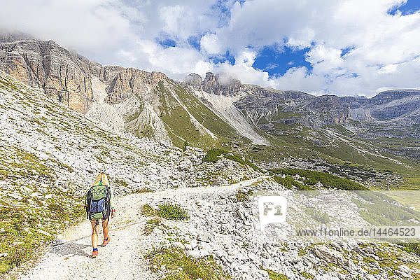 A hiker walks the path for Pian di Cengia Refug  Dolomites of Sesto (Sexten)  Province of Belluno  Veneto  Italy