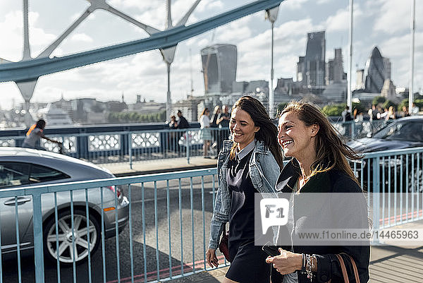 UK  London  zwei glückliche Frauen gehen auf der Tower Bridge